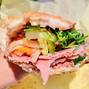 a hand holding a sandwich