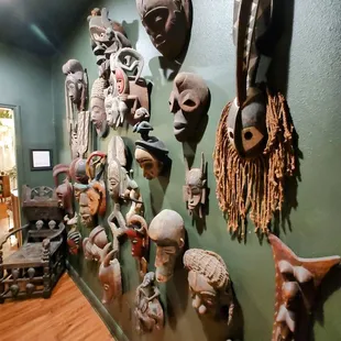a collection of african masks on a wall