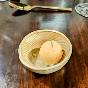 a bowl of ice cream on a wooden table