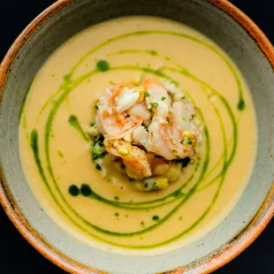 a bowl of soup with shrimp and broccoli