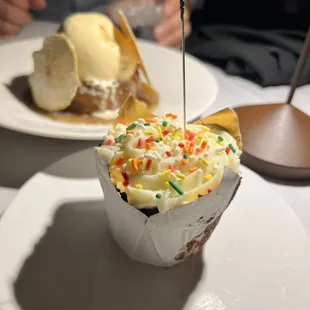 a cupcake with ice cream and sprinkles