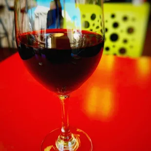 a glass of red wine on a table