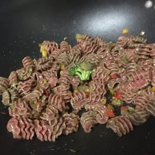 Cooked rigatoni beet pasta prepared at home loaded with veggies