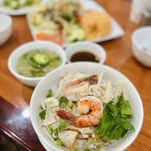 a bowl of noodles with shrimp and vegetables