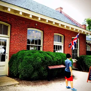 a little boy standing in front of the building