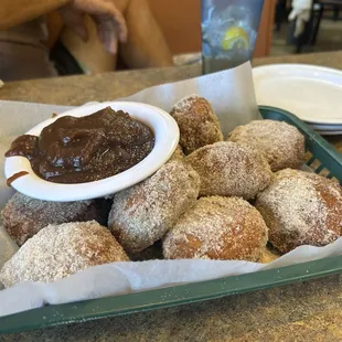 Fried biscuits dusted with cinnamon sugar with a side of sweet apple butter.