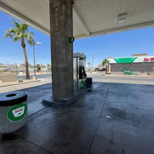 a gas pump and trash can
