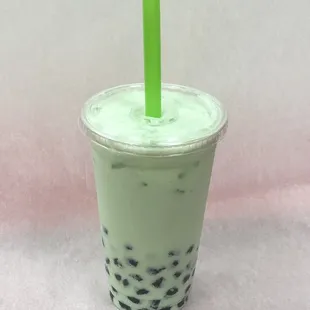 a plastic cup with a green straw
