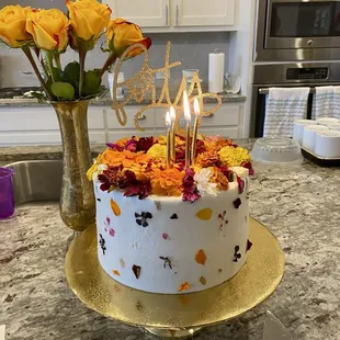 a birthday cake with candles and flowers