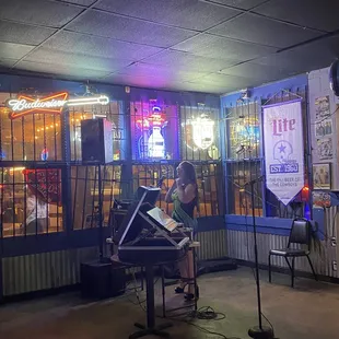 a woman sitting at a piano in front of a restaurant