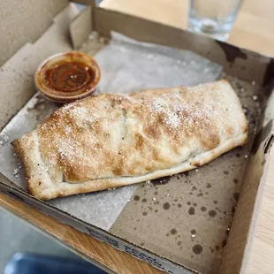 Stromboli with pepperoni, green peppers, onion, mozzarella cheese, and mushrooms