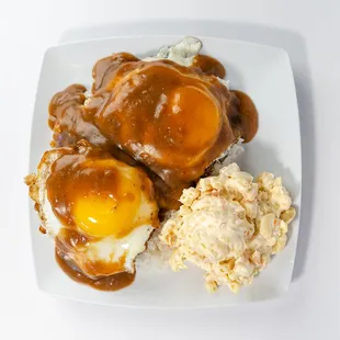 Loco Moco Plate  Enjoy a juicy hamburger patty topped with a fried egg and smothered in savory gravy, served with macaroni salad and rice