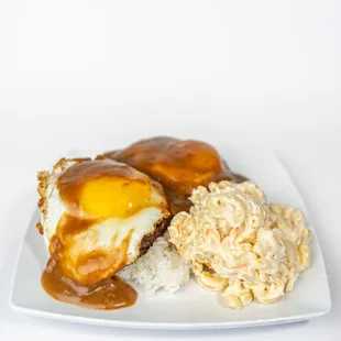 Loco Moco Plate  Enjoy a juicy hamburger patty topped with a fried egg and smothered in savory gravy, served with macaroni salad and rice