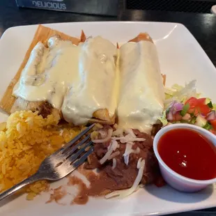 Three delicious pork tamales with house queso, rice and beans!