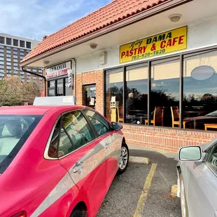 a red car parked in front of the restaurant
