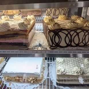 Vegan cakes, including raspberry chocolate at top left, mango chocolate at top right, velvet at bottom right, and lemon rum at bottom left