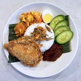 Nasi Lemak: Ayam goreng, coconut rice, egg, pickles, peanuts, crispy anchovies, sambal tumis | $22