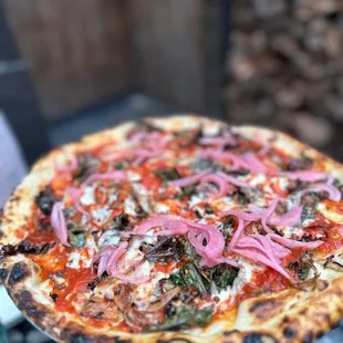 a pizza with onions and other toppings