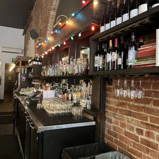 a brick bar with bottles of wine