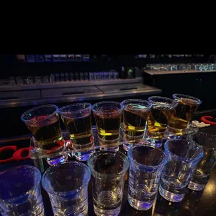 a variety of shot glasses on a bar counter