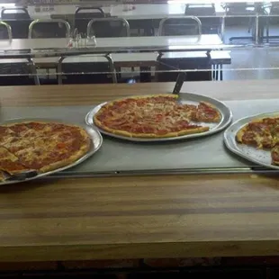 three pans of pizza
