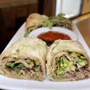 a plate of meat and vegetable wraps