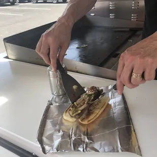 a person cutting a sandwich