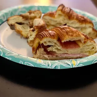 a half eaten sandwich on a paper plate