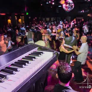 a large group of people dancing at a party