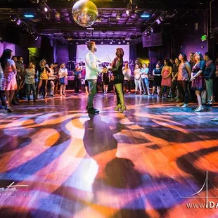 a group of people dancing on a dance floor