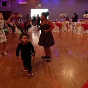 a little girl in a black dress and a little girl in a pink dress