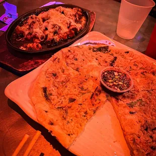 two pizzas on a table with drinks