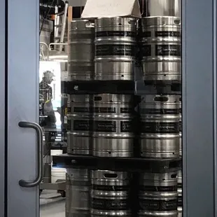 a large stack of beer kegs