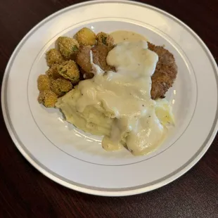 Country fried steak with mashed potatoes and gravy and fried okra
