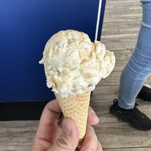 a hand holding a cone of ice cream