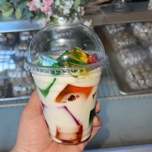 a hand holding a cup of yogurt