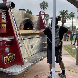 a man putting a pizza in the oven