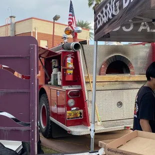 a fire truck with a pizza oven in the back