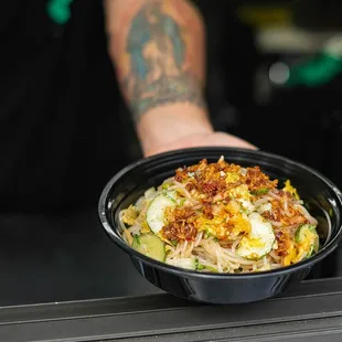 a man holding a bowl of food