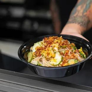 a person holding a bowl of food