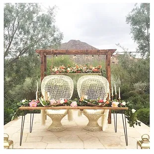 Hanging backdrops , peacock chairs , and a modern farm table.