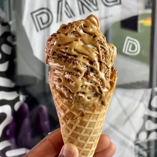 Vanilla soft serve  topped with Reese&apos;s and cookie butter sauce