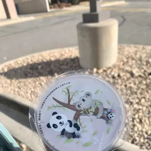 a person holding a cup with pandas on it