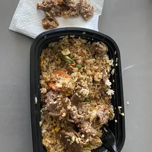 a bowl of rice with meat and vegetables