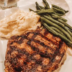 12oz Ribeye Steak with garlic mashed potatoes and green beans.