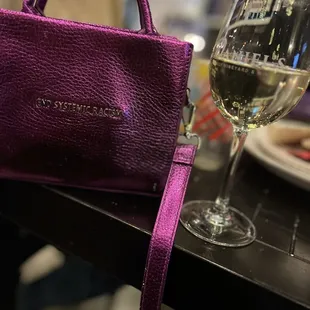 a glass of wine and a purse