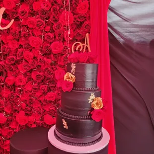 a three tiered cake with red roses