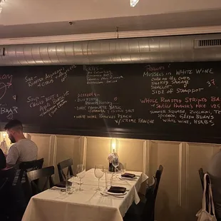 a restaurant with a chalkboard menu on the wall