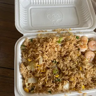 a takeout container with rice and shrimp