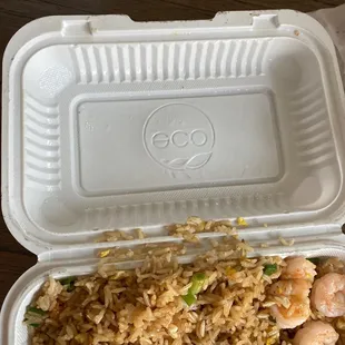 a takeout container with rice and shrimp